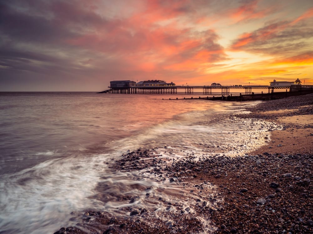 Cromer pier and beach at sunrise on a winters morning