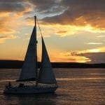 Dramatic sunset behind sailing boat in Studland Bay