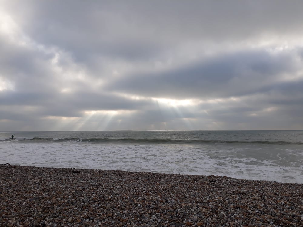 Sunrays coming trough the clouds over Bracklesham Bay beach