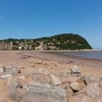 Minehead beach and seafront towards the harbour in summer with blue sky on a beautiful day