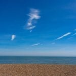 Empty shingle beach with blue sky and light wispy clouds. Aldeburgh Beach, Aldeburgh, Suffolk