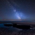 Stunning vibrant Milky Way composite image over landscape of Southerdown beach (Dunraven Bay)