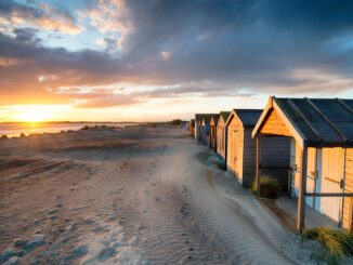 Stunning sunset over beach huts at West Wittering on the Sussex coastline