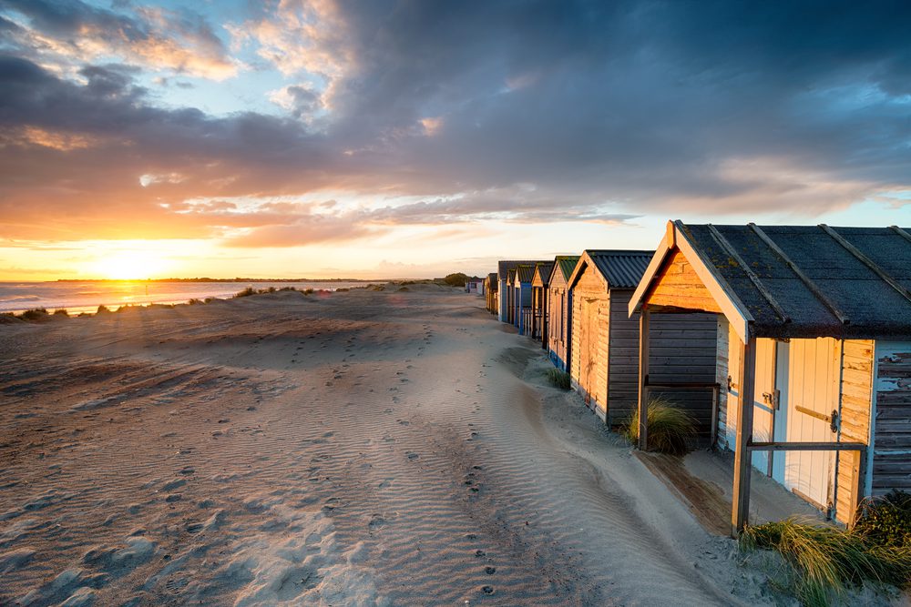 Stunning sunset over beach huts at West Wittering on the Sussex coastline